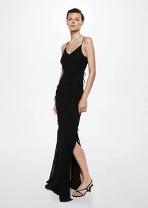 Detail of high side slit and ruffled layers on a black backless evening maxi dress