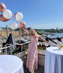 Détail d'une robe maxi en mousseline fleurie rose avec col en V, découpes et volants au bas
