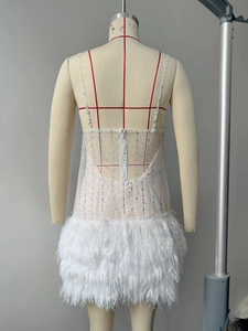 Detail of white sequin mesh party dress with feather hem and thin back straps