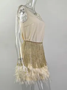 Close-up of champagne satin dress with golden fringes and cream feather trim detail