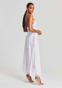 Detailed view of white backless vacation dress with delicate lace trim and tie details