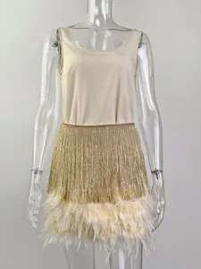 Detail of evening party set featuring golden metallic fringe and beige feather trim skirt