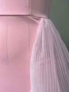 Detailed view of pale pink evening dress featuring pleated tulle patchwork on satin fabric