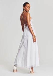 Close-up of white backless dress featuring lace embroidery and lace-up ribbon details