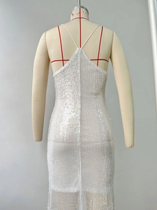 Detail of the backless sequin dress with thin criss-cross straps and mesh fishtail hem