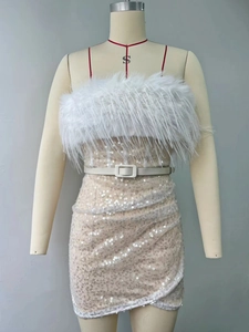Détail de robe à paillettes avec plumes blanches, décolleté bustier et ceinture