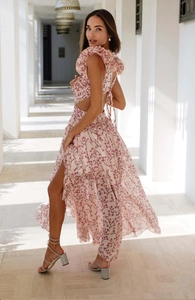 Détail d'une robe fleurie rose avec dos nu à nouer et fente haute sur la jambe
