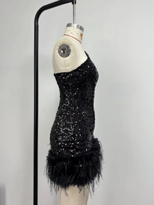 Détail de la robe à paillettes avec ourlet en plumes noires et silhouette ajustée
