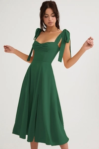 Detail of forest green midi dress with bow shoulder straps and high side slit