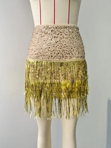 Detail view of sparkly gold sequins and long fringe tassels on the tight party skirt