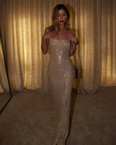Close-up of champagne gold sequin evening gown with delicate straps and slim silhouette