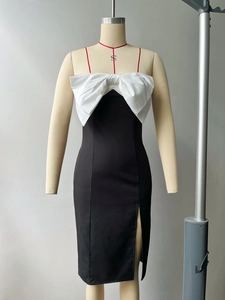 Detail view of contrast white bow on a black slim fit dress with high side slit
