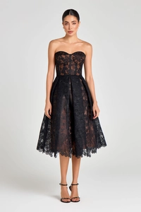 Detail of elegant black floral lace over nude lining on a midi tube dress