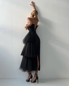 Detailed view of the layered black mesh ruffles and side slit on the elegant evening gown