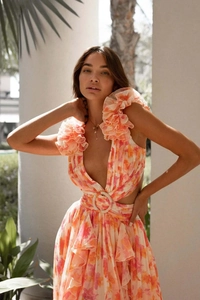 Détail d'une robe fleurie avec col en V, volants superposés et boucle à la taille