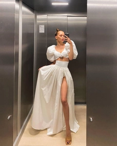 Mirror selfie showing white puff sleeve crop top and high waist slit long skirt details