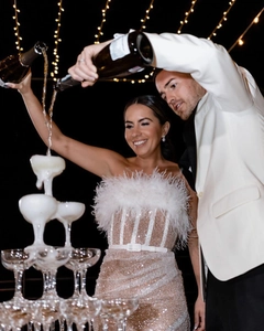 Détail de la robe à paillettes blanches avec plumes de luxe et scène de tour de champagne