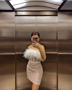 Détail de la robe à paillettes champagne avec garniture en plumes et fine ceinture à la taille