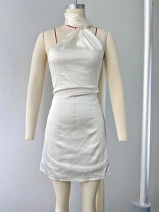 Detail of white backless satin halter dress with elegant pearl luster and pleated waist