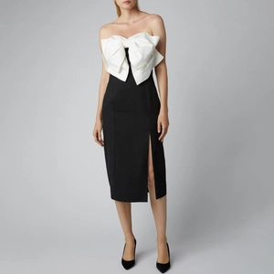 Elegant black and white strapless dress with a large white bow and side slit design