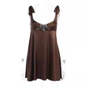 Detail of dark brown satin dress with hollow cut-out design and metal buckle closure