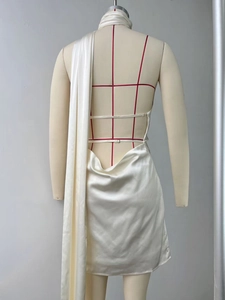Detail of white satin backless halter dress showing draped fabric and elegant ribbon tie