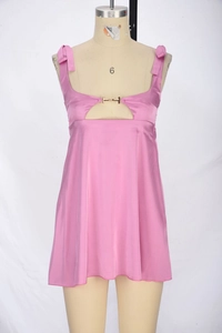 Detail of pink satin dress featuring bow shoulder straps and gold metal buckle cutout