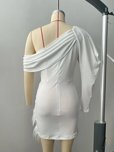 Detail of white one-shoulder dress showing back view and textured feather trim hemline