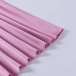 Close-up of pink satin dress featuring delicate ruffle hem and professional stitching