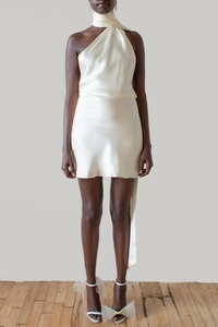 Detail of a creamy satin halter mini dress featuring an elegant backless cut and long streamers
