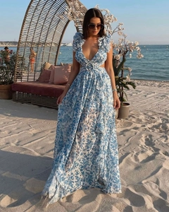 Détail d'une robe maxi à fleurs bleues avec décolleté en V profond et épaules à volants