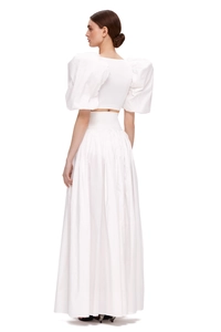 Side view of white two-piece set with puff sleeves and long high-waisted pleated skirt