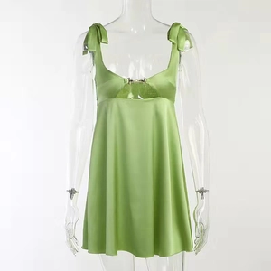 Green satin mini dress with bow straps and hollow-out metal buckle detail on white background