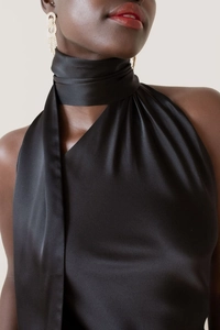 Detail of elegant black satin halter neck dress with glossy silk texture and long scarf collar