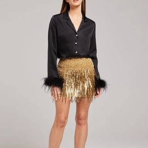 Women's party set featuring black feather cuff satin shirt and gold sequin fringe skirt