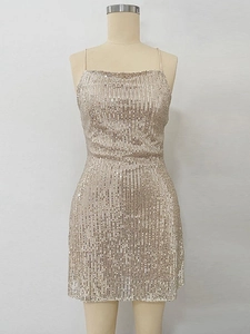 Détail de sequins dorés champagne sur une robe de soirée courte à fines bretelles