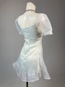 Detail view of white organza mini dress showing bubble sleeves and rear hidden zipper