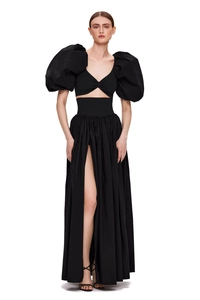 Detail of elegant black two-piece set featuring puff sleeves and high-slit pleated skirt