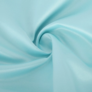 Gros plan détaillé du tissu en satin bleu clair avec plis élégants et texture brillante