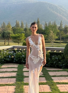 Close-up of white sheer mesh dress with 3D floral appliques and deep V-neckline details