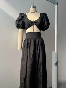 Detail of black puff sleeve dress showing U-neckline, bow knot and waist cutout design