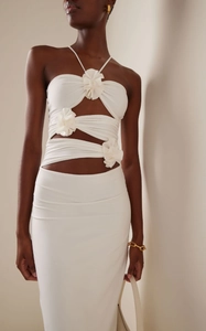 Detailed close-up of 3D floral accents and halter cut-out design on white summer dress