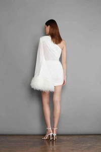 Detail of elegant white one-shoulder mini dress with soft feather trim on the flared sleeve