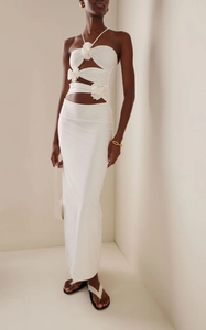 Detailed shot of white 3D floral accents on a sexy cutout halter neck long dress