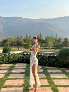 Detailed view of white lace floral embroidery on a sexy backless sheer slit maxi dress