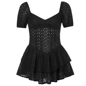 Detailansicht der schwarzen Lochstickerei auf einem gestuften Mini-Kleid