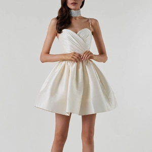 Détail de la mini-robe en satin ivoire avec bretelles en strass et décolleté plissé