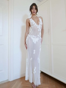 Detailed view of the 3D floral appliqués on a white sheer tulle V-neck evening gown