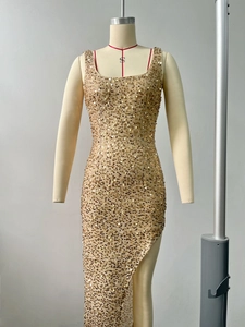 Dettaglio di abito da sera in paillettes oro champagne con spacco alto e scollo quadrato