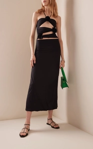 Detail of elegant black dress showing neck cutout and 3D floral accent on the fabric